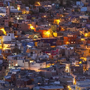 Mexico, Guanajuato. Street lights add ambience to this twilight village scene