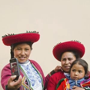 Modern life in Peru family in traditional dress and hat taking photo with cell phone communicating