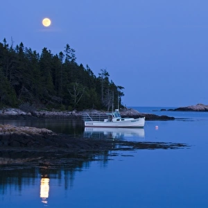 Full moon illuminates lobster boats in Bunker Harbor, Maine, USA