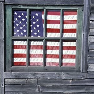 NA, USA, Maine, Georgetown Island. Flag of the United States in window of abandoned store