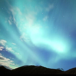 North America, USA, Alaska, Brooks Range. Brilliant green aurora borealis lights up clouds