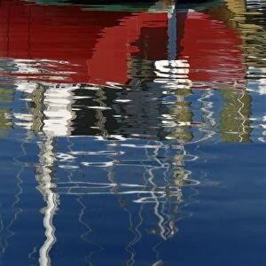 North America, USA, Florida, Titusville, Red sailboat and red, white and blue reflections on water