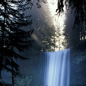 North America, USA, Washington. Waterfall with rays of light shining through mist
