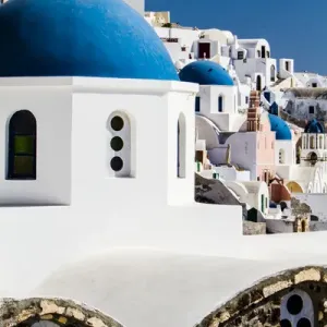 Oia, Greece. Row of Greek Orthdox Churches with blue domes and painted pastel white Oia, Greece. Row of Greek Orthdox Churches with blue domes and painted pastel white