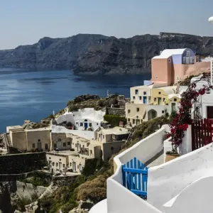 Oia, Santorini, Greece. Village of Oia with blue and red wooden gates and painted Oia, Santorini, Greece. Village of Oia with blue and red wooden gates and painted