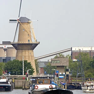 Old windmill and boats in the harbor at Rotterdam, Netherlands