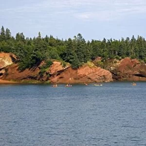 People sea kayaking in the Bay of Fundy at St. Martins, New Brunswick, Canada