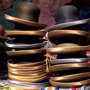 Peru. Pile of felt hats with satin rims on a pile of woven mantas
