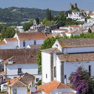 Portugal, Obidos. Ancient, red, terra cotta tiled roof tops, lines. Old windows