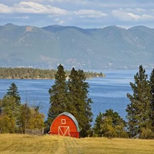 Red barn sits along scenic Flathead Lake near Rollins, Montana