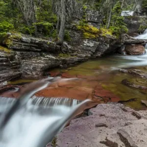 Red rocked Virginia Creek in Glacier National Park, Montana, USA