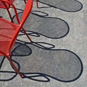 Red wire chairs shadows on concrete Red wire chairs shadows on concrete