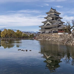 The reflection of the Matsumoto Castle and the castle against the mountain backdrop in