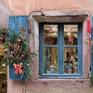 Riquewihr, France. Village established in the 1400s in the Alsace Region. Window decorated with Christmas ornaments
