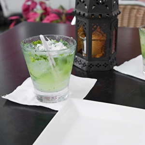 San Juan, Puerto Rico - Two alcoholic beverages are sitting on a table next to a lantern
