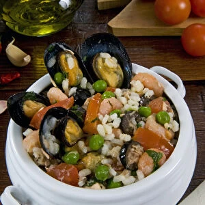 Seafood rice with mussels, shrimps, tomato, olives, peas, Italian cuisine, Italian food