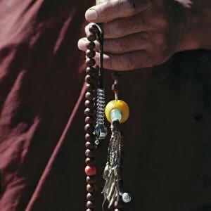 Sikkim, Gangtok. A monk holds graceful prayer beads at Rumtek Monastery, Gangtok, Sikkim