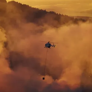 Smokey sunset and helicopter fighting fire at Burnside, Dunedin, South Island, New Smokey sunset and helicopter fighting fire at Burnside, Dunedin, South Island, New