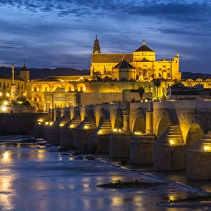 Spain, Andalusia. Cordoba. The Roman bridge across the Guadalquivir river at dusk