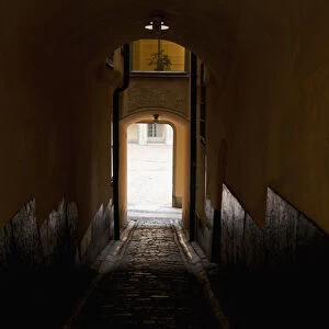 Stockholm, Sweden - Image of a dark, enclosed walkway. Sunlight can be seen from the arched exit