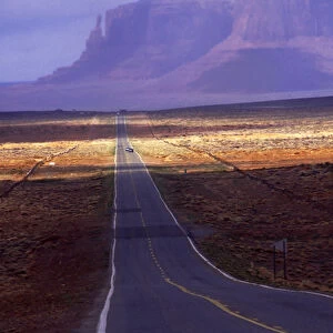 Straight road with desert waves heading for Monument Valley, Utah