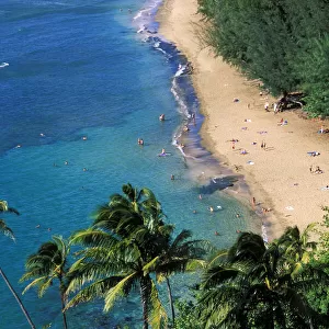 Sunbathers and blue Pacific waters at Ke e Beach, North Shore, Island of Kauai