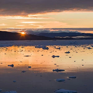Sunset over fjord with icebergs close to Eqip Glacier in Greenland, Danish Territory