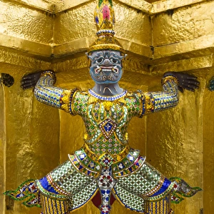 Thailand, Bangkok. Yaksha (demons) guard one of the golden chedi at Wat Phra Kaew