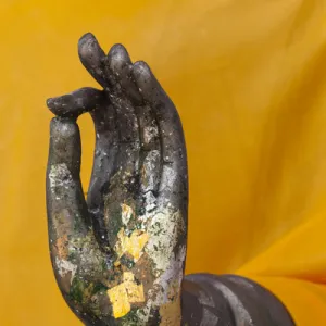 Thailand. Buddha Statue hand with gold leaf tokens