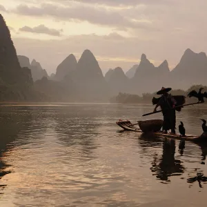 Traditional Chinese fisherman with cormorants on Li River at sunrise, near Guilin, China