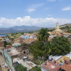 La Trinidad de Cuba desde arriba con torre y iglesia y montañas con edificios de techos de tejas. La Trinidad de Cuba desde arriba con torre y iglesia y montañas con edificios de techos de tejas.