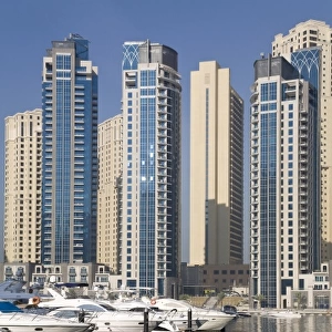 UAE, Dubai. Marina towers with boats at anchor