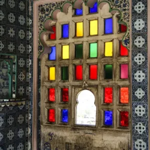 Udaipur, Rajasthan, Inde. Fenêtre de verre coloré avec carreaux byzantins et arcade en escalope. Udaipur, Rajasthan, Inde. Fenêtre de verre coloré avec carreaux byzantins et arcade en escalope.