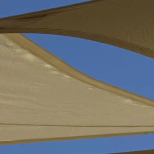 United Arab Emirates, Fujairah. Sand-colored canvas awnings under blue sky. Credit as