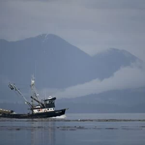 USA, Alaska, Angoon, FV Lady Jane, a salmon fishing boat, motors past fog-shrouded