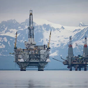 USA, Alaska, Offshore oil drilling rigs in Cook Inlet and distant Alaska Range peaks