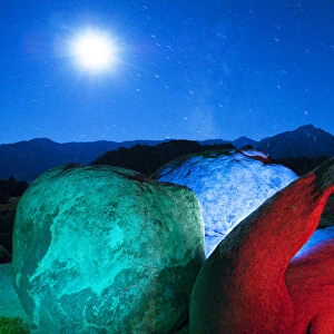 USA, California, Alabama Hills. Mobius Arch and rocks lit with colors on moonlit night