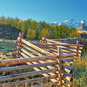 USA, Colorado, Quray. Dallas Divide, sunrise on the Mt. Snaffles with autumn colors and split rail fence