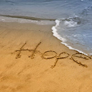 USA, Maine, Phippsburg. The word hope carved in Popham Beach sand near surf. Credit as