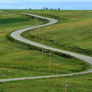 USA, Montana, Browning. A rural righway snakes over the countryside near Browning