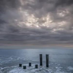 USA, New Jersey, Cape May National Seashore. Beach pilings on stormy sunrise. Credit as USA, New Jersey, Cape May National Seashore. Beach pilings on stormy sunrise. Credit as