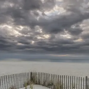 USA, New Jersey, Cape May National Seashore. Beach fence and stormy sunrise. Credit as USA, New Jersey, Cape May National Seashore. Beach fence and stormy sunrise. Credit as