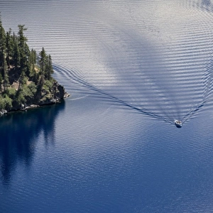 USA, Oregon, Crater Lake NP. The calm water of Crater Lake is broken by the wake