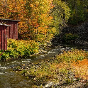 USA, Vermont, Stowe, red mill on Little River as it flows south of Stowe to Winooski River, fall foliage