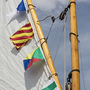 USA, Washington. Boat sail and flags at Bainbridge Island Wooden Boat Festival. Credit as