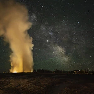 USA, Wyoming, Yellowstone National Park. Milky Way over an erupting Old Faithful Geyser