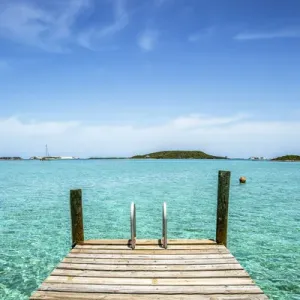 Foto vertical con un muelle en primer plano, agua clara y cielo azul en el fondo. Foto vertical con un muelle en primer plano, agua clara y cielo azul en el fondo.