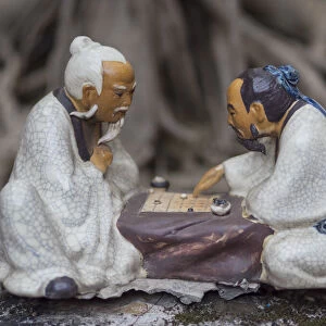 Vietnam, Hanoi. Temple of Literature, painted ceramics of 2 men playing traditional game