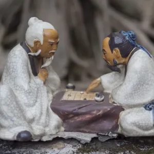Vietnam, Hanoi. Temple of Literature, painted ceramics of 2 men playing traditional game