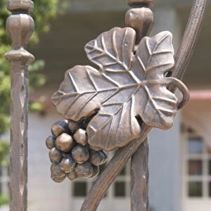 Wrought iron grape bunch and vine leaf on the entrance gate to the winery. Podrum